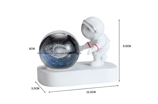Decorative figure of an astronaut pushing a galaxy ball with measurements on a white background