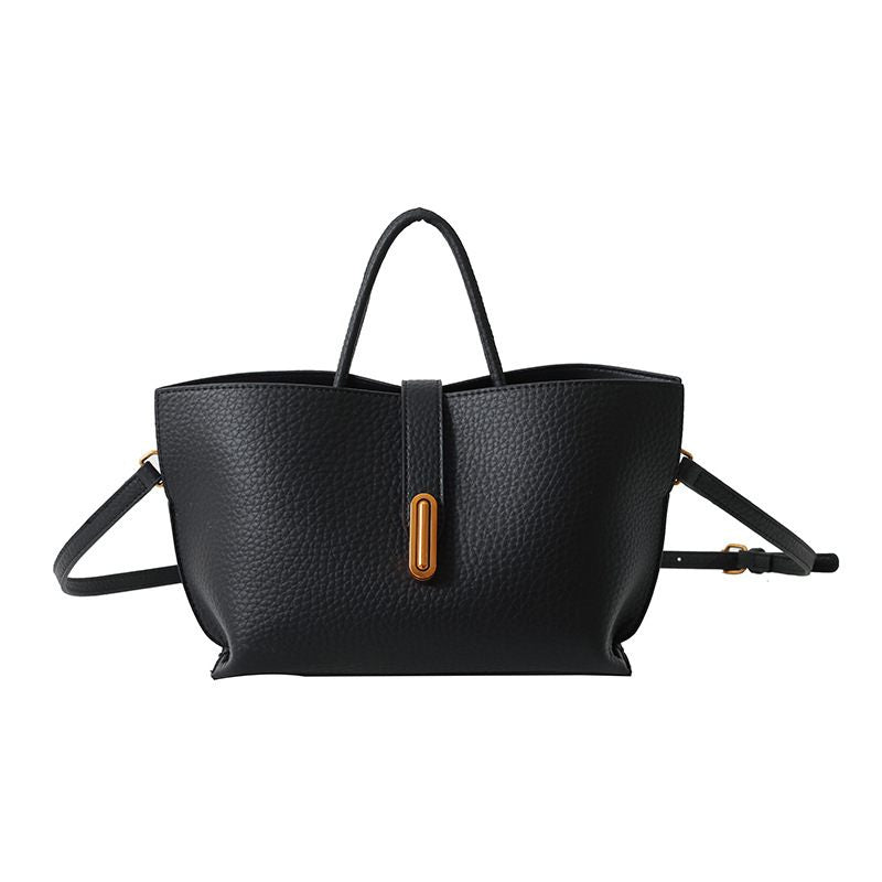 Black leather handbag with a gold clasp on a white background
