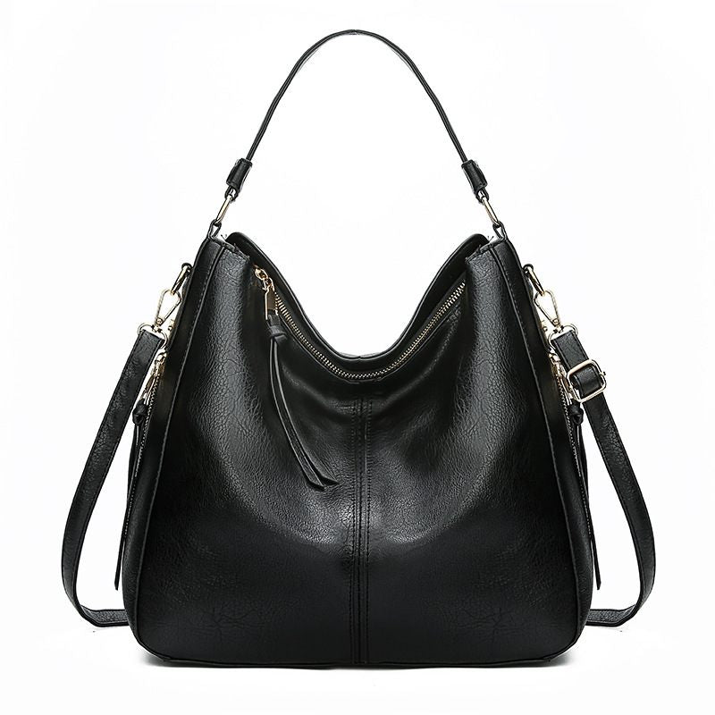 Black leather handbag with shoulder straps on a white background