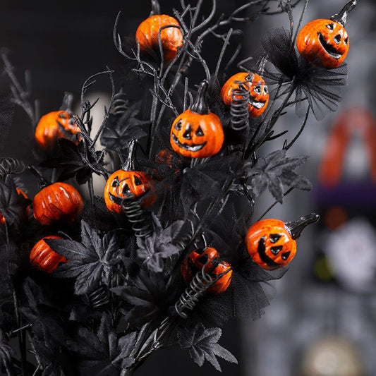 Halloween decorative branch with jack-o'-lantern pumpkins on black background