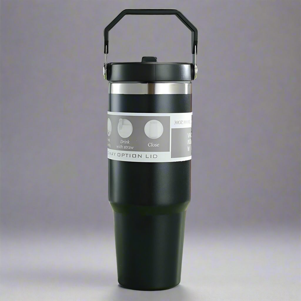 Black insulated tumbler with silver lid on a gray background