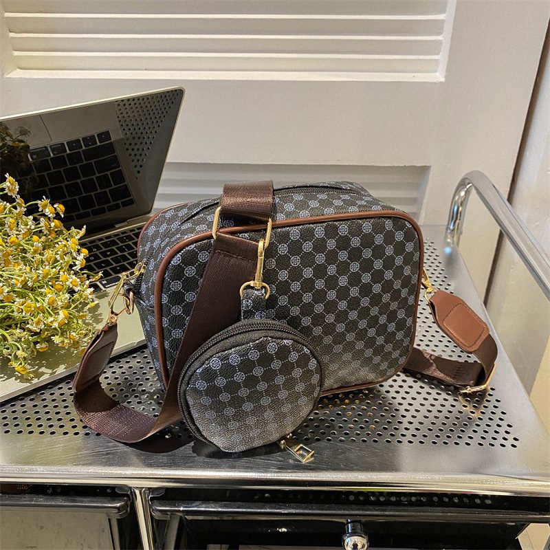 Patterned duffel bag with brown accents on a metal surface