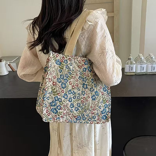 Person wearing a floral tote bag in an indoor setting