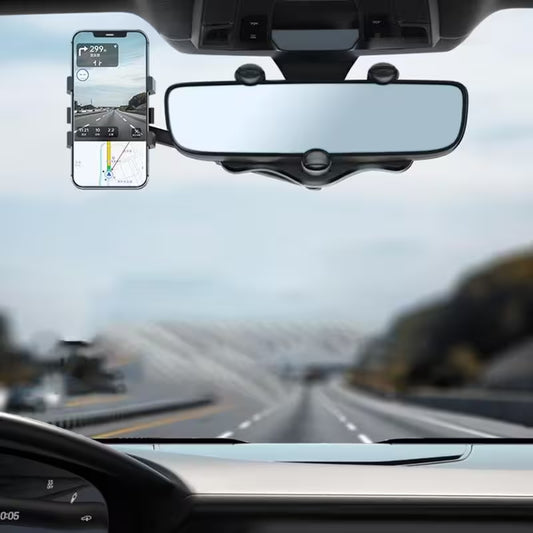 Car interior with a rearview mirror and smartphone mount, showing a road ahead.