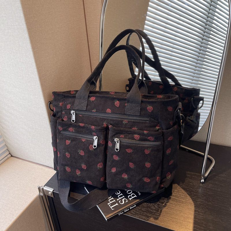Black patterned handbag on a surface with a book underneath