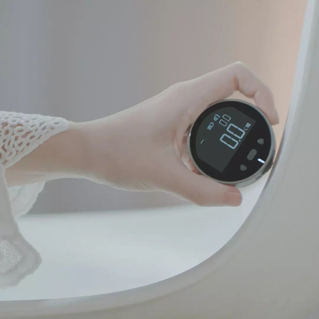 Hand holding a digital device near a round mirror with a blurred background