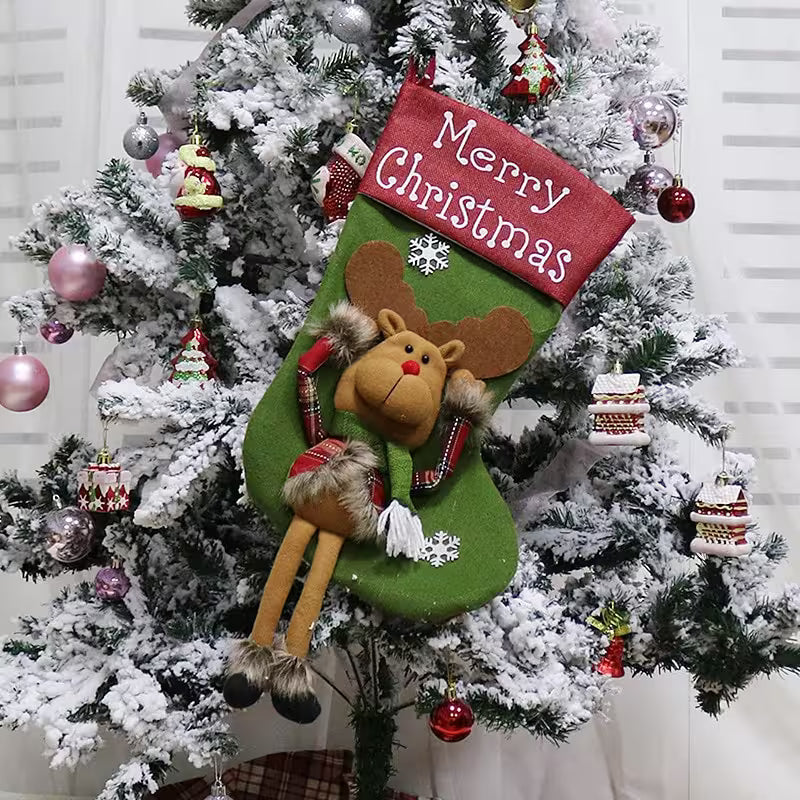 Decorative Christmas stocking with a reindeer design hanging from a Christmas tree.