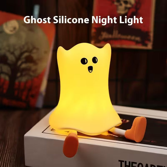 Ghost silicone night light on a surface with Halloween-themed decorations in the background
