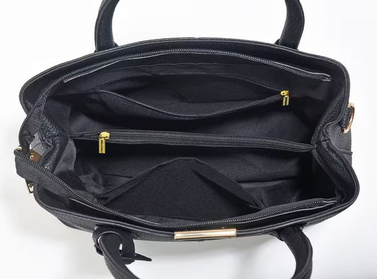 Black handbag with gold zippers and accents on a white background