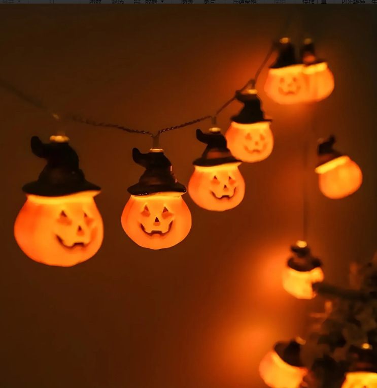 String of Halloween-themed lights shaped like jack-o'-lanterns with witch hats on a dark background.