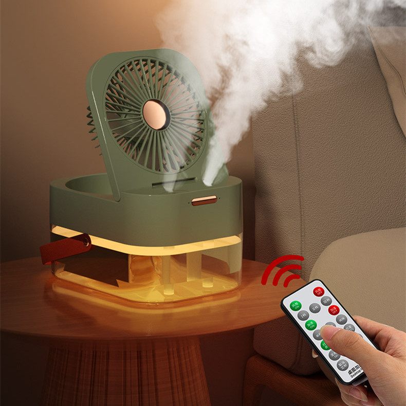 Green humidifier with steam coming out and a remote control held by a hand.