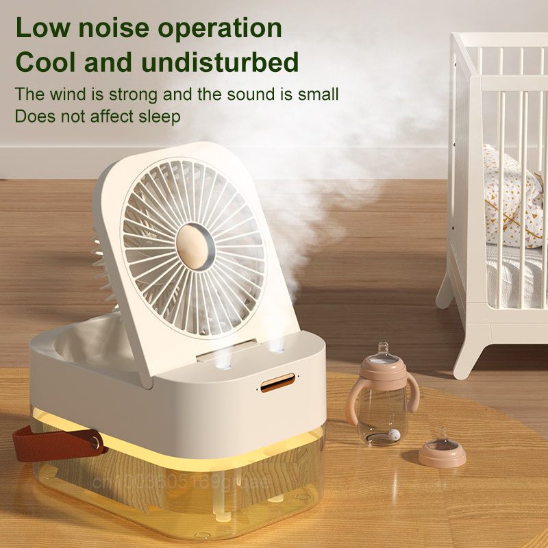 Portable fan with mist feature on a wooden floor next to a crib, with text highlighting its noise reduction and cooling properties.