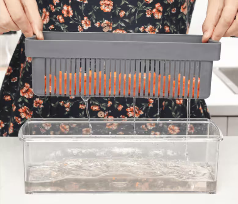 Person using a kitchen tool with a clear container and orange slices.