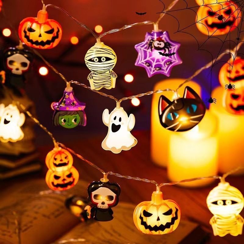 Halloween-themed string lights with various characters on a wooden surface.