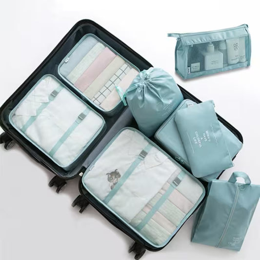 Set of travel packing cubes and bags in light blue on a white background