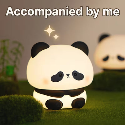 Cute panda-shaped night light on a grassy surface with a blurred background
