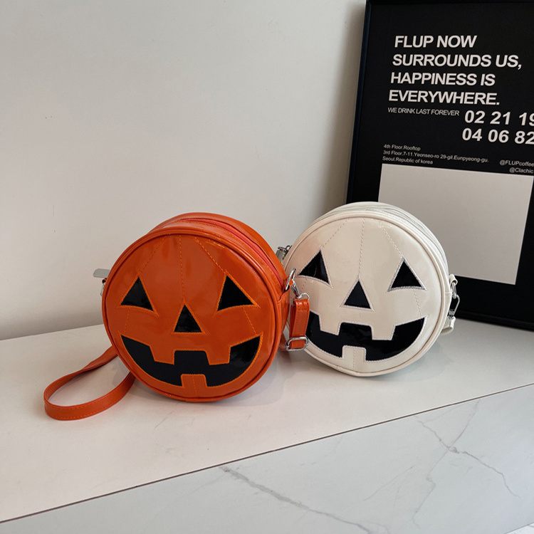 Two round bags with jack-o'-lantern faces on a white surface.