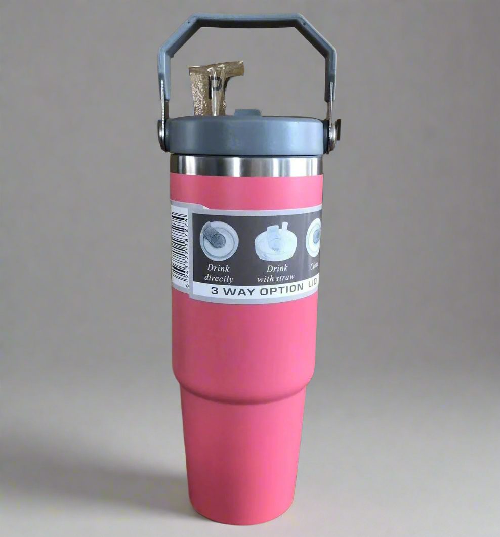 Pink insulated tumbler with a gray lid on a gray background