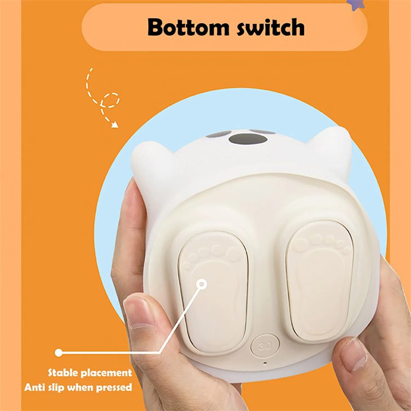 Person holding a white night light with cat ears and text indicating 'Bottom switch' on an orange background.