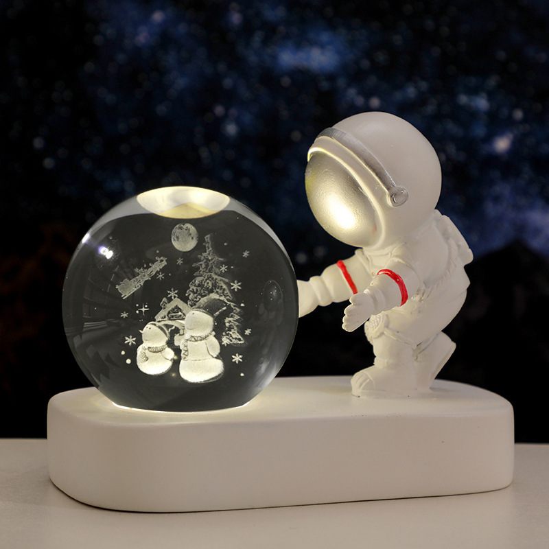 Astronaut interacting with a snow globe against a dark space background