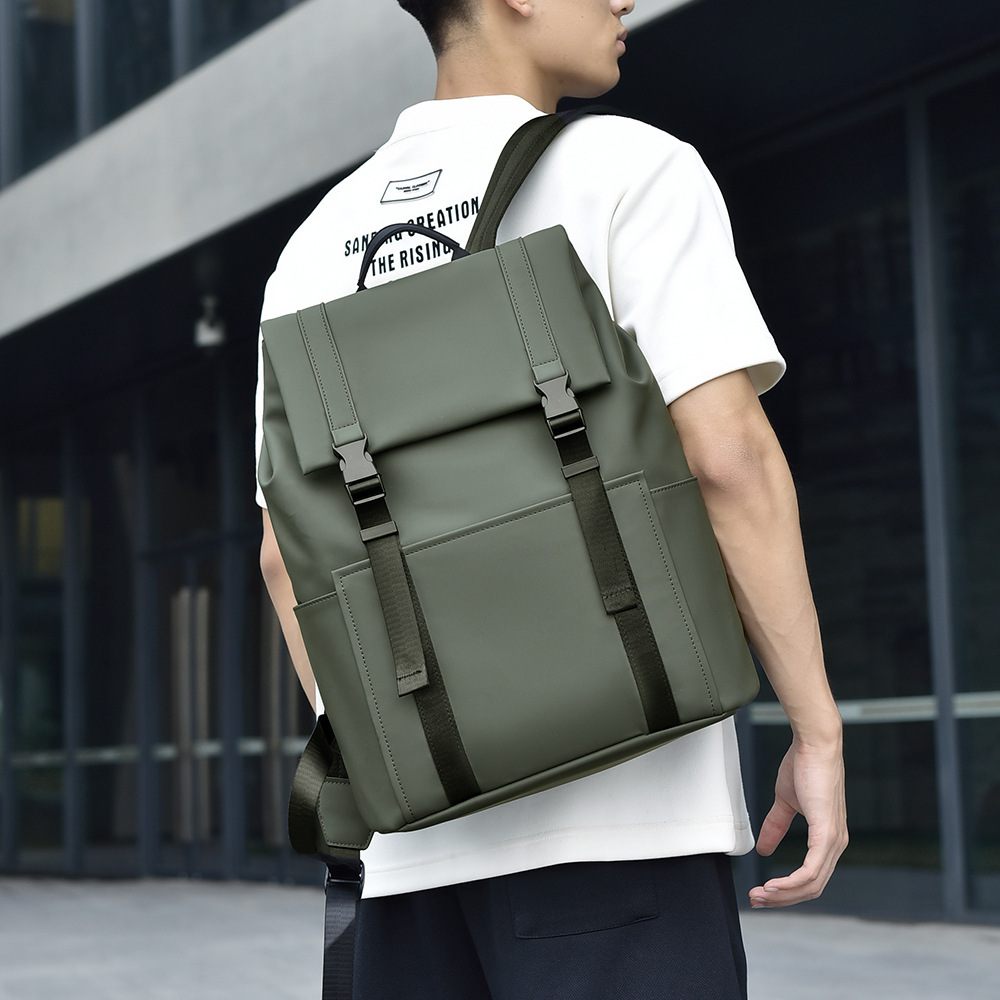 Person wearing a green backpack in an urban setting
