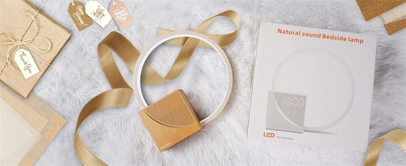 Bedside lamp with beige base and white shade on a textured surface with ribbons and a card.