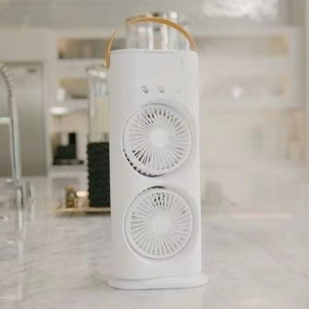 White cylindrical fan with decorative elements on a blurred background