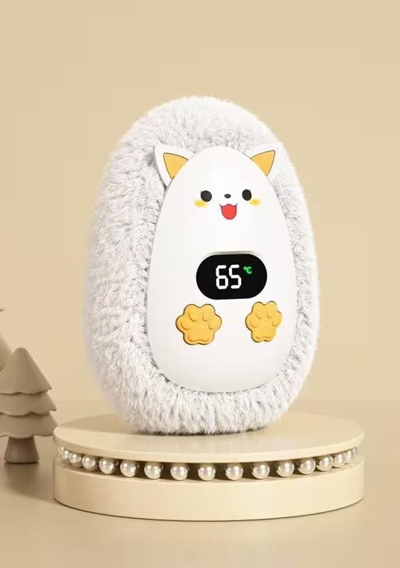 Fluffy white pet heater with cartoon face and digital display on a beige background