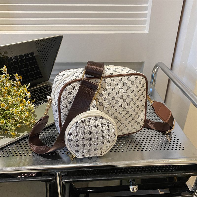 Patterned handbag with matching round pouch on a metal surface
