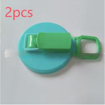 Green and blue plastic clip with '2pcs' text on a light gray background