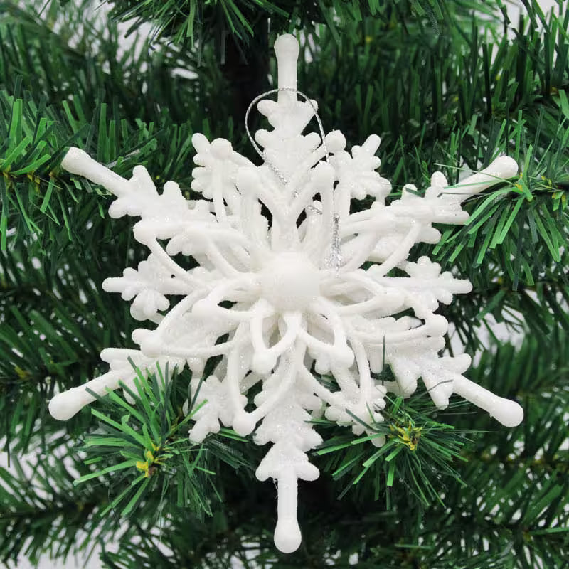 White snowflake ornament on a green Christmas tree