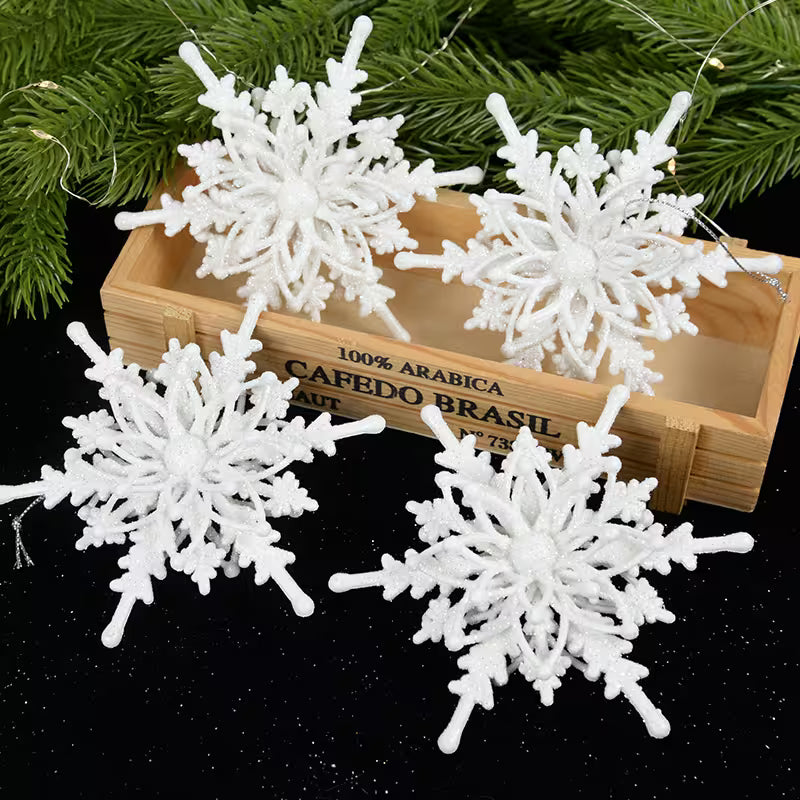 White snowflake decorations on a black surface with a wooden box labeled 'Cafédo Brasil' in the background.