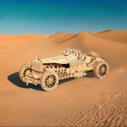 Wooden model of a vintage car on sand dunes with clear blue sky