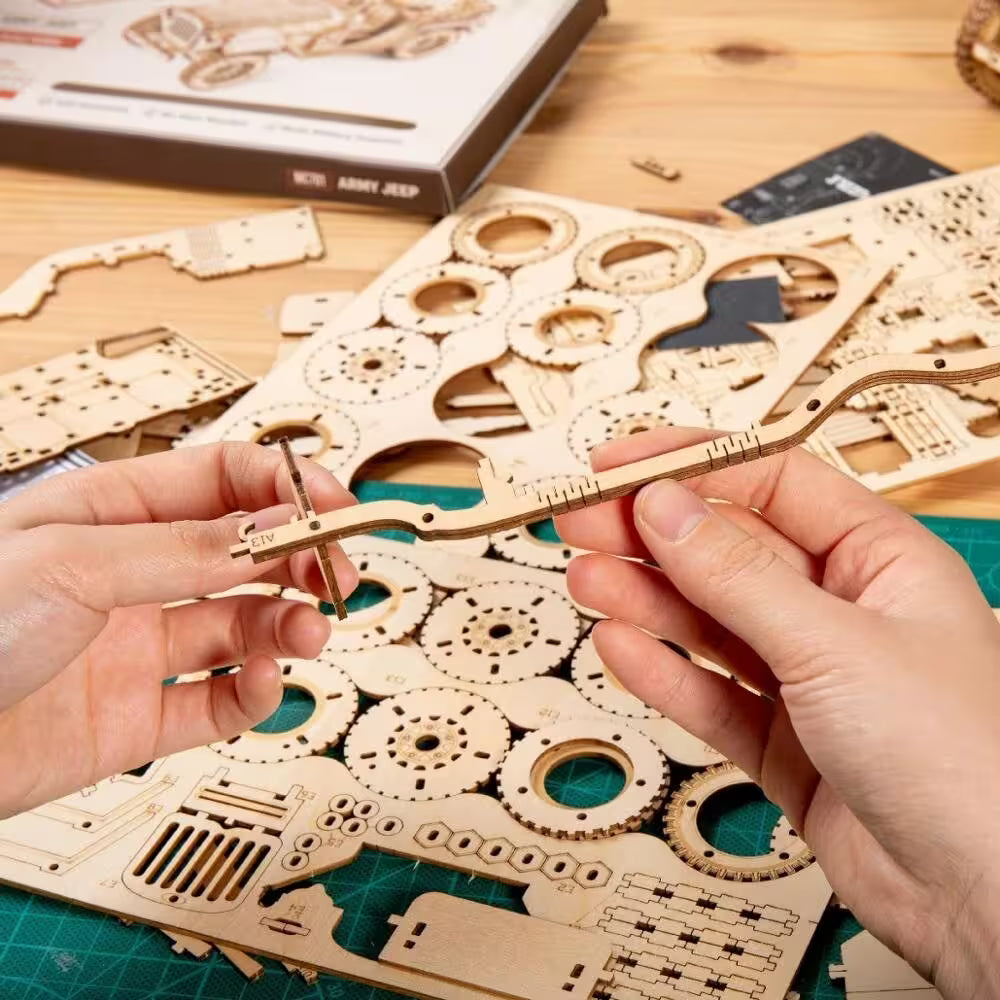 Wooden mechanical model kit with hands using tools on a wooden table