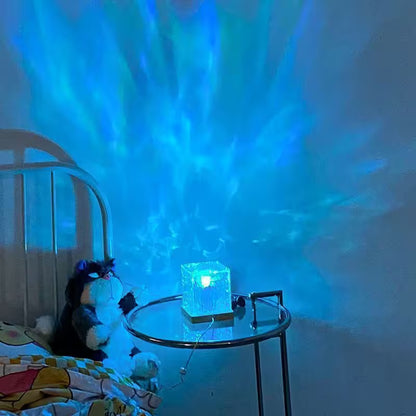 Room with a night light projecting a blue light onto the wall, next to a bed with a plush toy.