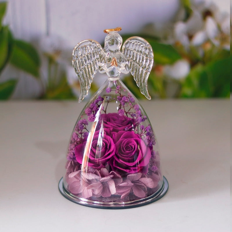 Angel statue made of clear glass with golden outline drawing wings, halo and folded palms.