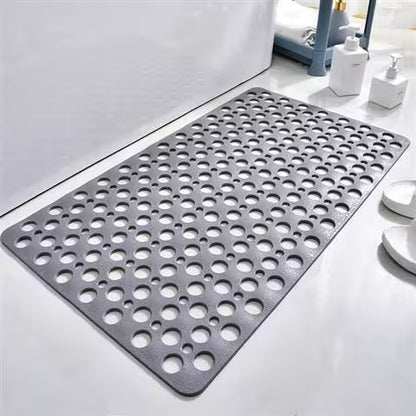 Gray perforated mat on a bathroom floor with cleaning supplies in the background