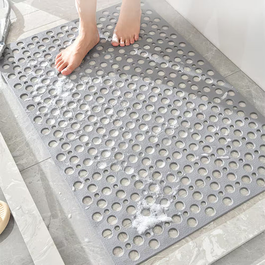 Gray bath mat with circular holes on a bathroom floor