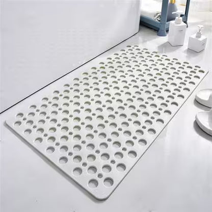 Gray bath mat with circular holes on a bathroom floor