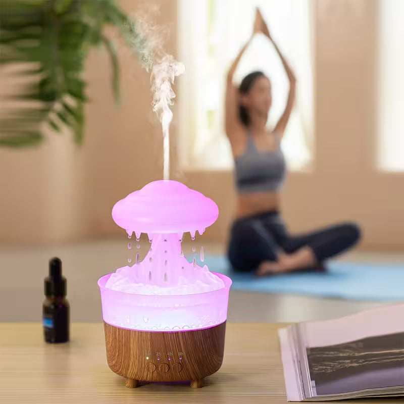 A mushroom-shaped diffuser emitting mist on a table with a blurred person exercising in the background.