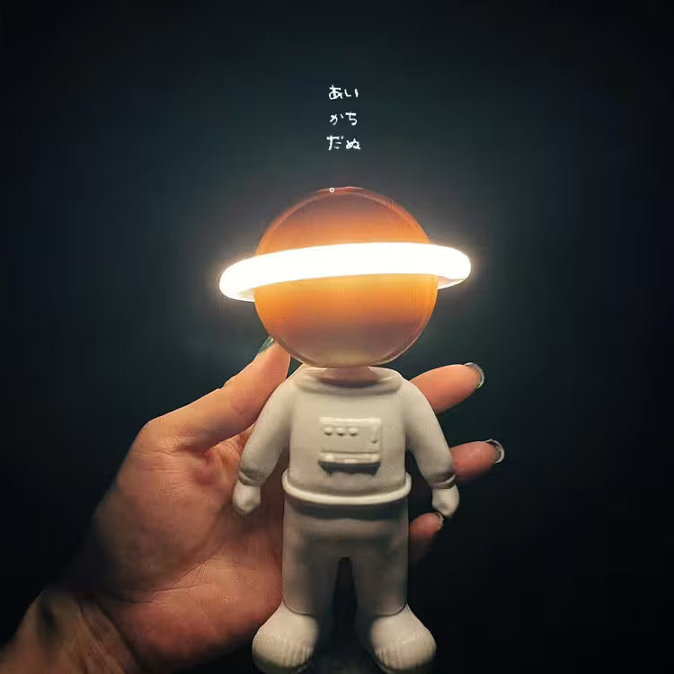 Toy figure with a glowing head held in a hand against a dark background