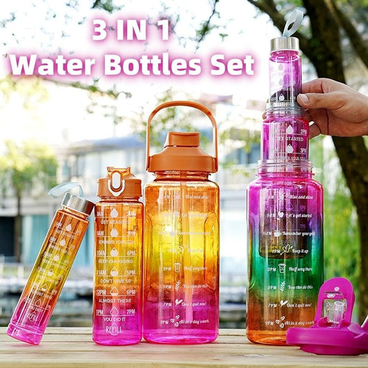 Set of three colorful water bottles with time markers on a wooden surface outdoors.