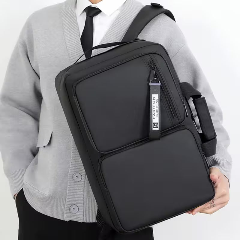 Person wearing a black crossbody bag with a visible brand label on a white background