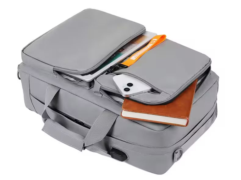 Gray backpack with items like a notebook and phone inside on a white background