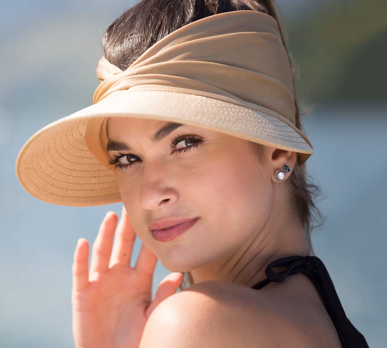 Woman wearing a beige visor hat with a blurred background