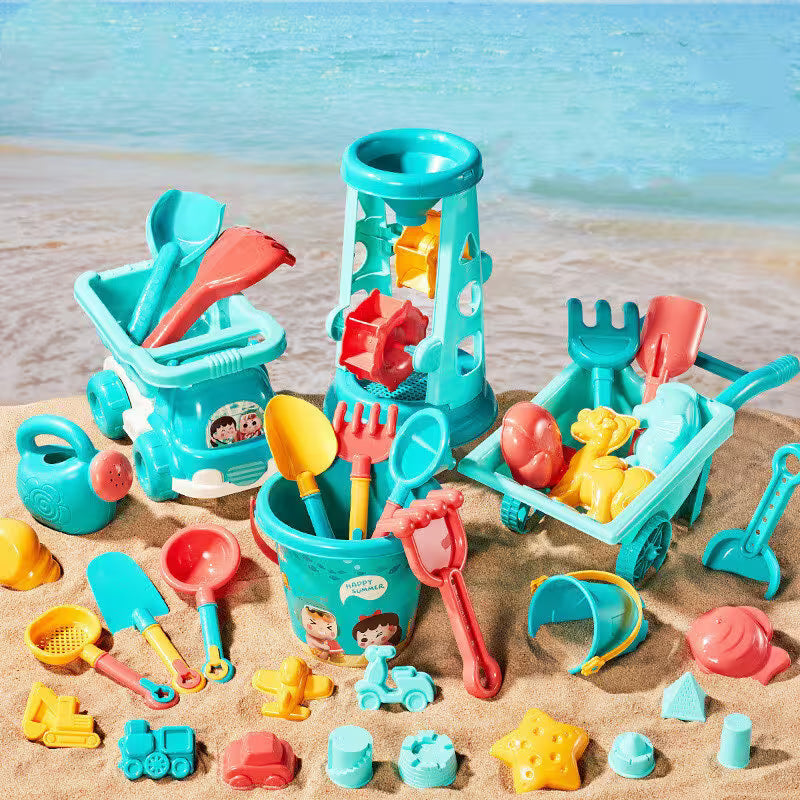 Collection of colorful beach toys on a sandy surface with a blurred beach background