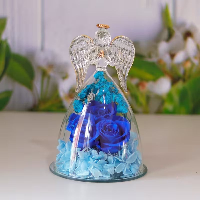Decorative angel figurine with blue roses under a glass dome on a blurred floral background