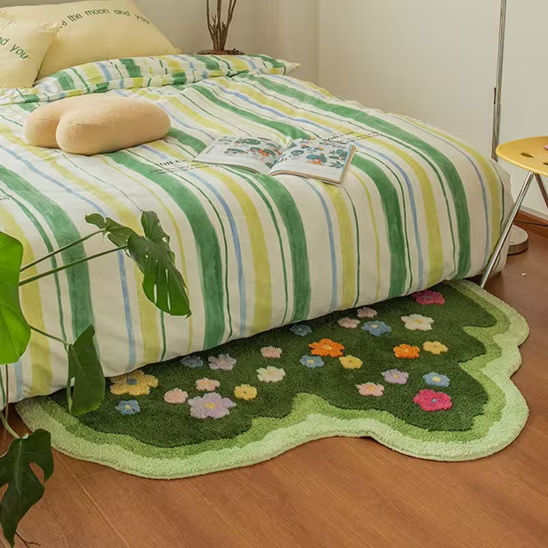 Bed with striped bedding and a floral rug on a wooden floor.