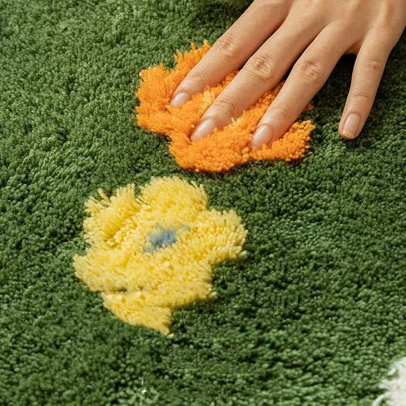 Hand touching a yellow and orange flower-shaped object on a green textured surface