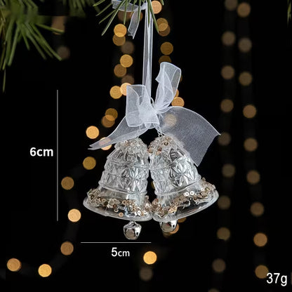 Decorative silver bell ornament with a bow, shown with measurements and weight on a blurred light background.